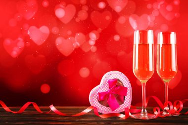 Kırmızı kalp üzerinde iki şampanya flüt gözlüklü kavramsal görüntü bokeh ışıklar şeklinde. Romantik akşam yemeği st Sevgililer günü için. Yakın çekim, alanı Kopyala. Farklı romantik günler için renkli arka plan