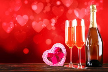 Kırmızı kalp üzerinde iki şampanya flüt gözlüklü kavramsal görüntü bokeh ışıklar şeklinde. Romantik akşam yemeği st Sevgililer günü için. Yakın çekim, alanı Kopyala. Farklı romantik günler için renkli arka plan