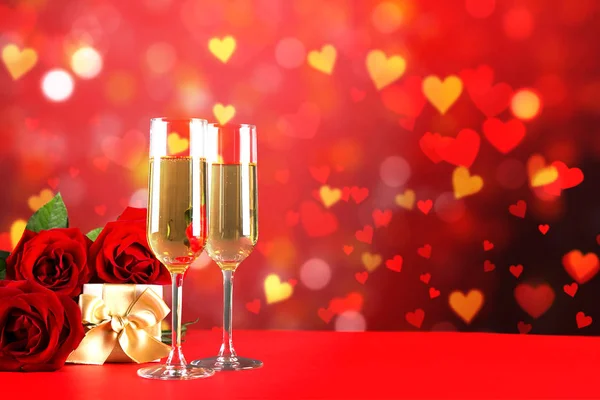 赤いハートの上の つのシャンパン フルート グラスで概念的なイメージは形ボケ ライトです 聖バレンタインの日ロマンチックなディナー クローズ アップ スペースをコピーします 異なったロマンチックな機会のためのカラフルな背景 — ストック写真