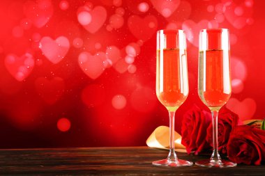 Kırmızı kalp üzerinde iki şampanya flüt gözlüklü kavramsal görüntü bokeh ışıklar şeklinde. Romantik akşam yemeği st Sevgililer günü için. Yakın çekim, alanı Kopyala. Farklı romantik günler için renkli arka plan