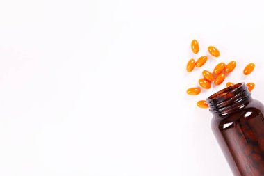 Tablo üzerinde dağınık turuncu haplarla c vitamini açık şişe şişe kavramsal görüntü. Üstten görünüm, kopya alanı, yakın çekim, arka plan.