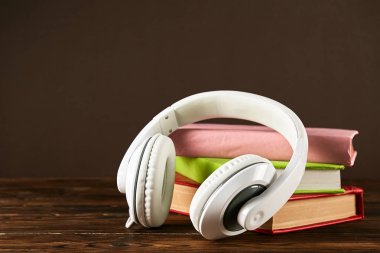 Elektronik audiobook vs normal kağıt kavramı kitap. Tablo boş renkli kapakları ve beyaz kulaklık ile farklı renk ciltli kitap yığını. Eski ve yeni. Yakın çekim, uzay, arka plan kopya.