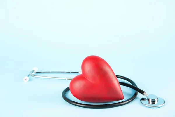 心臓病の認識と予防のコンセプトです コピーのテキストのための領域の多くで淡青色の孤立した背景に聴診器と赤の心 クローズ アップ トップ ビュー 心臓医療機器 — ストック写真