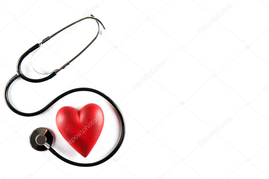 Heart disease awareness and prevention concept. Stethoscope and red heart on white isolated background with a lot of copy space for text. Close up, top view. Medical equipment for cardiologist.