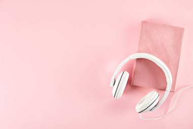 Elektronik audiobook vs normal kağıt kavramı kitap. Tablo boş renkli kapakları ve beyaz kulaklık ile farklı renk ciltli kitap yığını. Eski ve yeni. Yakın çekim, uzay, arka plan kopya.