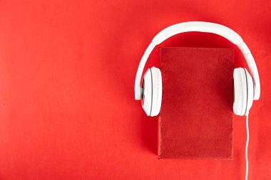 Elektronik audiobook vs normal kağıt kavramı kitap. Tablo boş renkli kapakları ve beyaz kulaklık ile farklı renk ciltli kitap yığını. Eski ve yeni. Yakın çekim, uzay, arka plan kopya.