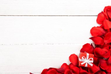 Romantik mutlu sevgililer günü düğün davetiyesi, kadın gün kavramı kartpostal. Beyaz arka plan koyu kırmızı, kırmızı, koyu kırmızı gül yaprakları ile kaplı. Üstten görünüm, yakın, uzay, alay kopyalayın.