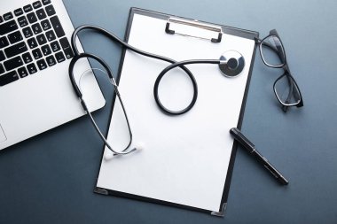 Modern tıbbi teknoloji ve yazılım gelişmeler kavram. Doktor stetoskop akustik aygıt, klavye, boş tıbbi kayıt içeren tablo çalışıyor. Yakın çekim, kopya alan arka plan, üstten görünüm, düz lay.