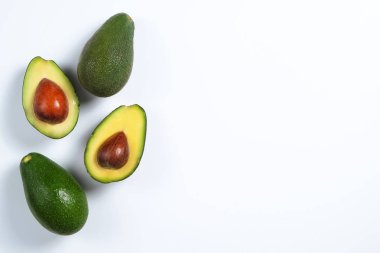 En az kompozisyon ile bütünleşmiş ve yarıya besin yoğun avokado meyve dilimleri kalp sağlıklı tekli doymamış yağ gri cam masa üstü dolu. Yakın çekim, kopya alanı, üstten görünüm, arka plan.