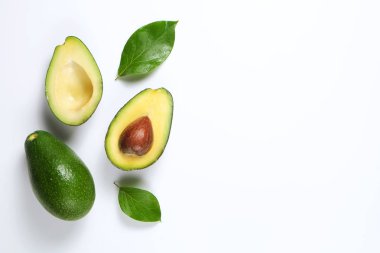 En az kompozisyon ile bütünleşmiş ve yarıya besin yoğun avokado meyve dilimleri kalp sağlıklı tekli doymamış yağ gri cam masa üstü dolu. Yakın çekim, kopya alanı, üstten görünüm, arka plan.