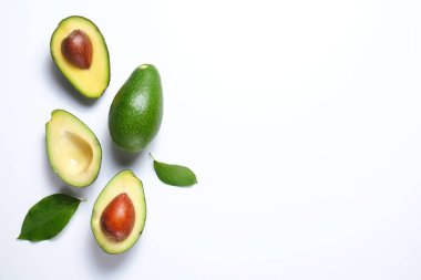 En az kompozisyon ile bütünleşmiş ve yarıya besin yoğun avokado meyve dilimleri kalp sağlıklı tekli doymamış yağ gri cam masa üstü dolu. Yakın çekim, kopya alanı, üstten görünüm, arka plan.