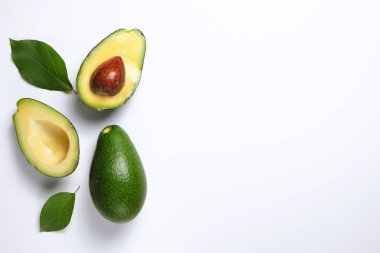 En az kompozisyon ile bütünleşmiş ve yarıya besin yoğun avokado meyve dilimleri kalp sağlıklı tekli doymamış yağ gri cam masa üstü dolu. Yakın çekim, kopya alanı, üstten görünüm, arka plan.