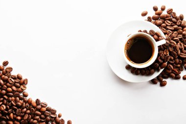 Metin için bir sürü yer Kopyala ile beyaz tabloda kahve fincanı kavrulmuş kahverengi fasulye ile dağınık. Düz yatıyordu kompozisyon. Yakın çekim, görünümü, arka plan top.