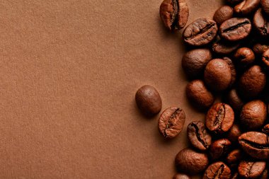 Taze kavrulmuş kahve çekirdekleri ile metin için bir sürü yer Kopyala kahverengi tabloda dağınık. Düz yatıyordu kompozisyon. Yakın çekim, görünümü, arka plan top.