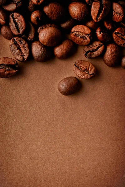 Taze kavrulmuş kahve çekirdekleri ile metin için bir sürü yer Kopyala kahverengi tabloda dağınık. Düz yatıyordu kompozisyon. Yakın çekim, görünümü, arka plan top.