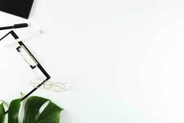 Kadın Blog yazar çalışma konsepti. Femenine masaüstü kompozisyon üzerinde büyük yeşil Monstera palmiye yaprağı. Arka plan, yakın çekim, kopya alanı, düz yatıyordu, üst görünüm.