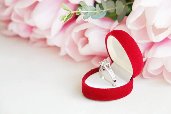 Крупним планом композиція з розкішним діамантовим кільцем і красивим букетом рожевих тюльпанів . — стокове фото