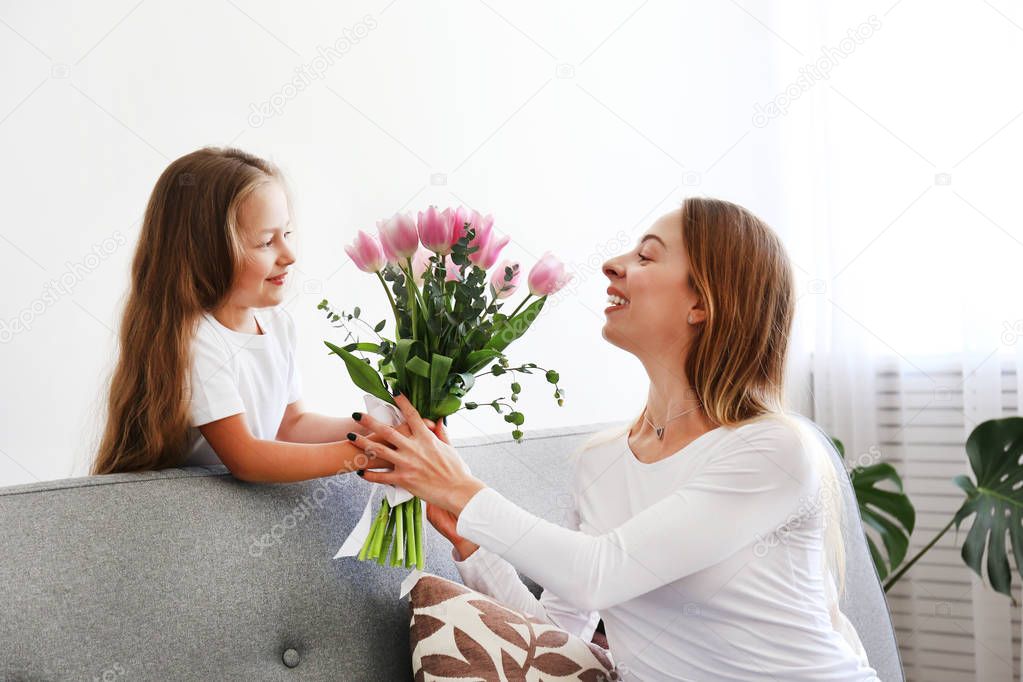 Happy mother's day concept. Little daughter congratulating her mother.