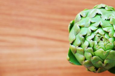 Taze yeşil İtalyan Enginar beyaz arka plan izole. Organik yerel ahşap doku masada sebze üretmek. Vegan diyeti. Temiz yeme konsepti. Yukarı, üstten görünüm, düz döşeme.