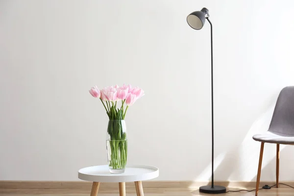 Hohes Interieur mit Blumen in Glasvase auf dem Tisch. — Stockfoto