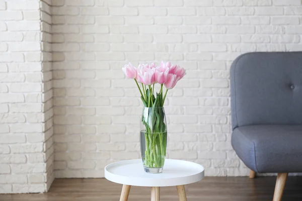 Hohes Interieur mit Blumen in Glasvase auf dem Tisch. — Stockfoto