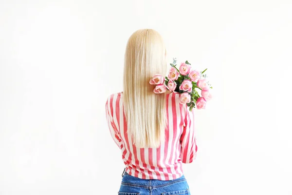 Jong blond vrouw in mam jeans en gewas top shirt holding boeket van tulpen. — Stockfoto