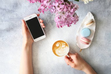 Çiçek ve elektronik cihazlar ile dokulu masa üzerinde Kadın eller.