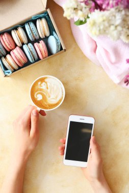 Çiçek ve elektronik cihazlar ile dokulu masa üzerinde Kadın eller.