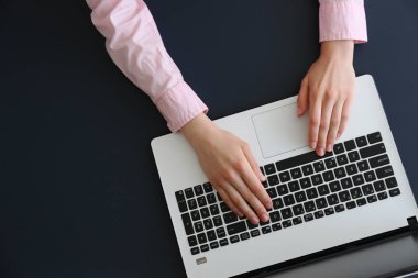 Genç bayan uzman dizüstü bilgisayarıyla çalışarak resmi kıyafet kazandı..