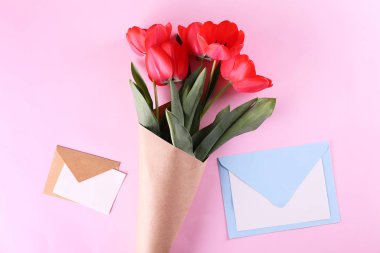 Kağıt ambalaj kırmızı lale buketi ile minimalist kompozisyon.