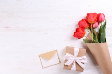 Kağıt ambalaj kırmızı lale buketi ile minimalist kompozisyon.