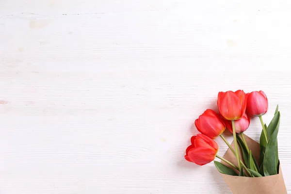 Minimalistisk komposition med Röda tulpaner bukett i pappersomslag. — Stockfoto