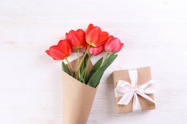 Kağıt ambalaj kırmızı lale buketi ile minimalist kompozisyon.