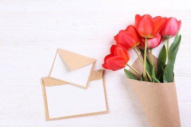 Kağıt ambalaj kırmızı lale buketi ile minimalist kompozisyon.