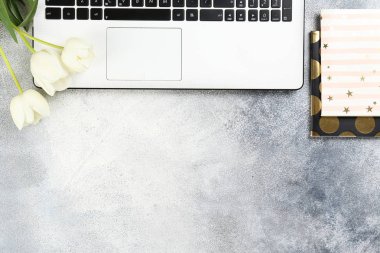 Kırmızı lale buketi ve dizüstü bilgisayar klavyesi ile minimalist kompozisyon.