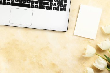 Kırmızı lale buketi ve dizüstü bilgisayar klavyesi ile minimalist kompozisyon.