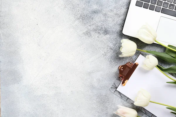 Minimalistic composition with red tulips bouquet and laptop keyboard.