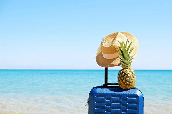 Pinapple en una maleta de plástico sobre el fondo de agua de mar . —  Fotos de Stock