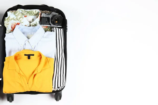 Plasthardshell resväska packad med casual kläder objekt. — Stockfoto
