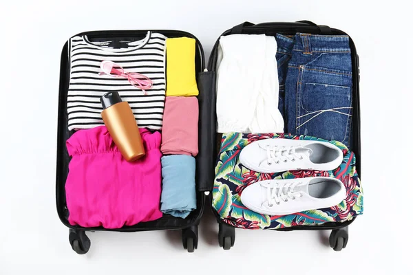 Plastic hardshell suitcase packed with casual clothing items.