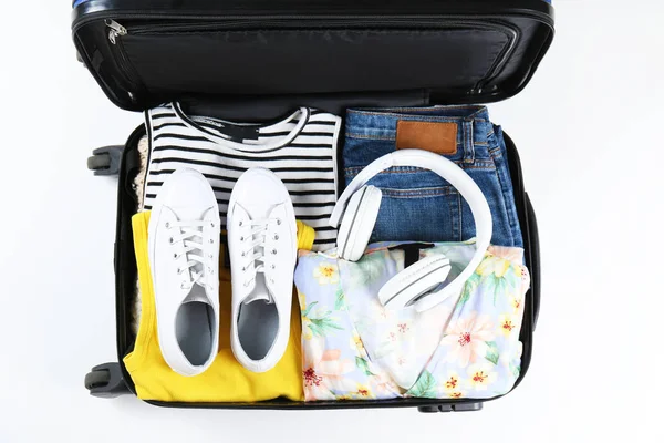 Пластикова валіза з твердою оболонкою упакована з предметами повсякденного одягу . — стокове фото