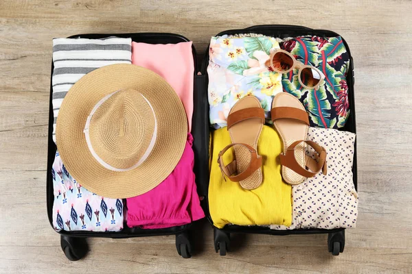 Plastic hardshell suitcase packed with casual clothing items. — Stock Photo, Image