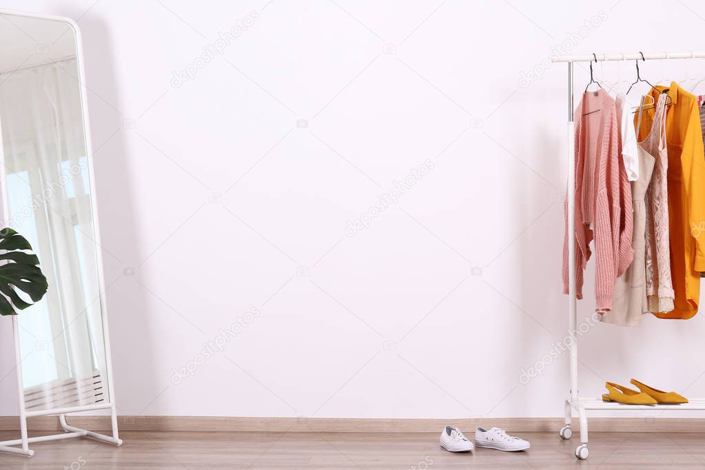 Different colorful casual clothing hanging in row.