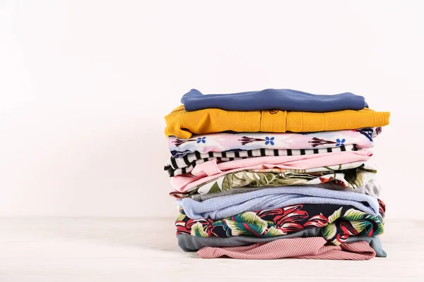 Bos van verschillende kleurrijke kleding items gevouwen in stapel. — Stockfoto