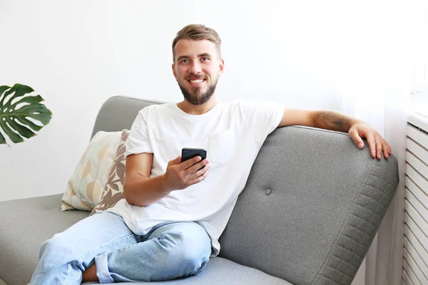 Joven con la barba llena escalofriante en su apartamento . — Foto de Stock