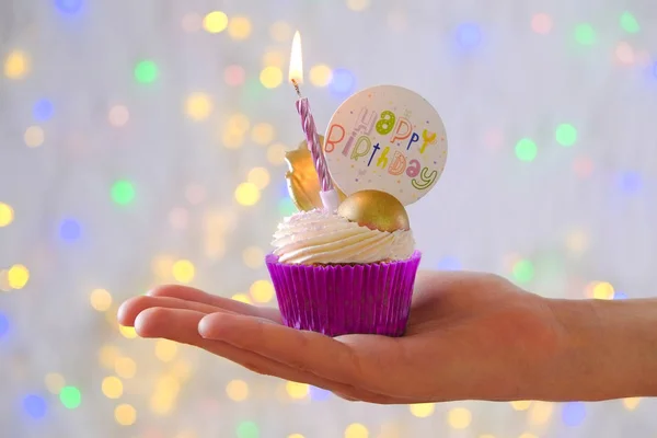 Dulce bizcocho orgánico feliz cumpleaños con vela encendida en envoltura púrpura, crema de queso glaseado remolino y decoración de chocolate dorado en mesa texturizada de madera blanca. Cerrar, copiar espacio, fondo . —  Fotos de Stock