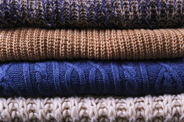 Mükemmel yığılmış farklı renk ve desenler örme kazak yığını.