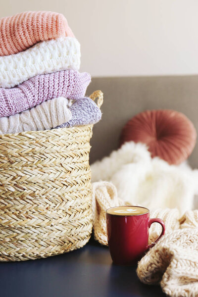 Pile of knitted sweaters of different colors and patterns perfectly stacked.