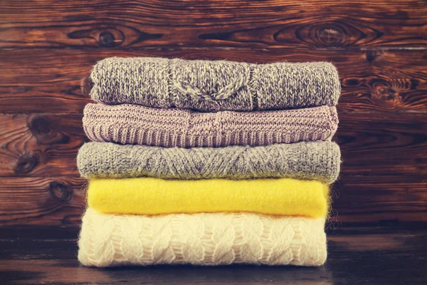 Montón de suéteres de punto de diferentes colores y patrones perfectamente apilados . — Foto de Stock