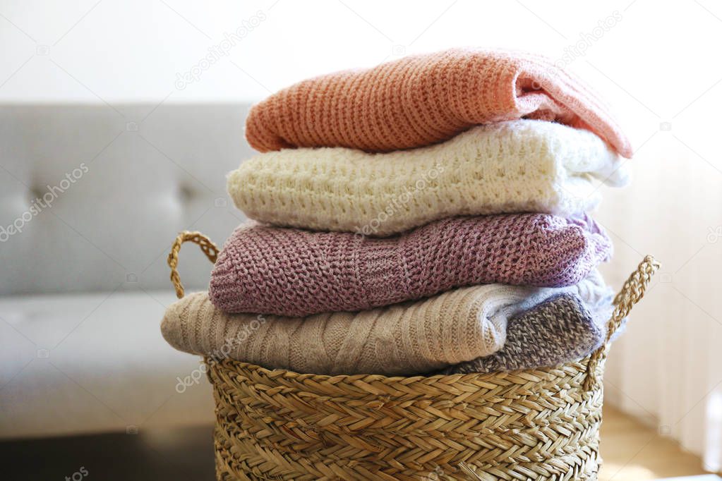Pile of knitted sweaters of different colors and patterns perfectly stacked.